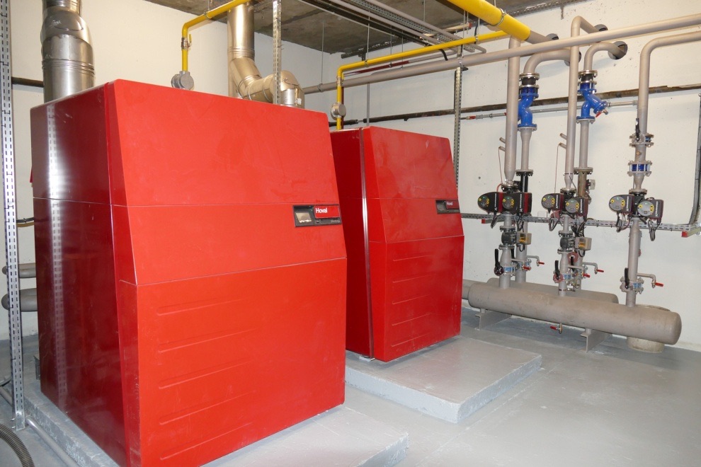 Chaufferie gaz équipée de deux chaudières et de son collecteur de distribution avec circulateurs et vannes d'isolement.