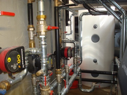 Local technique avec circulateurs, ballon de stockage et réseaux hydrauliques calorifugés.